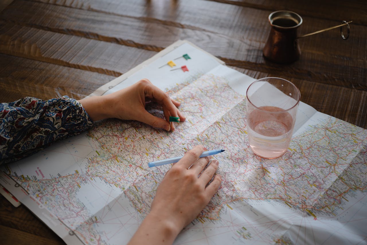 Person planning a sabbatical route on a paper map with pins