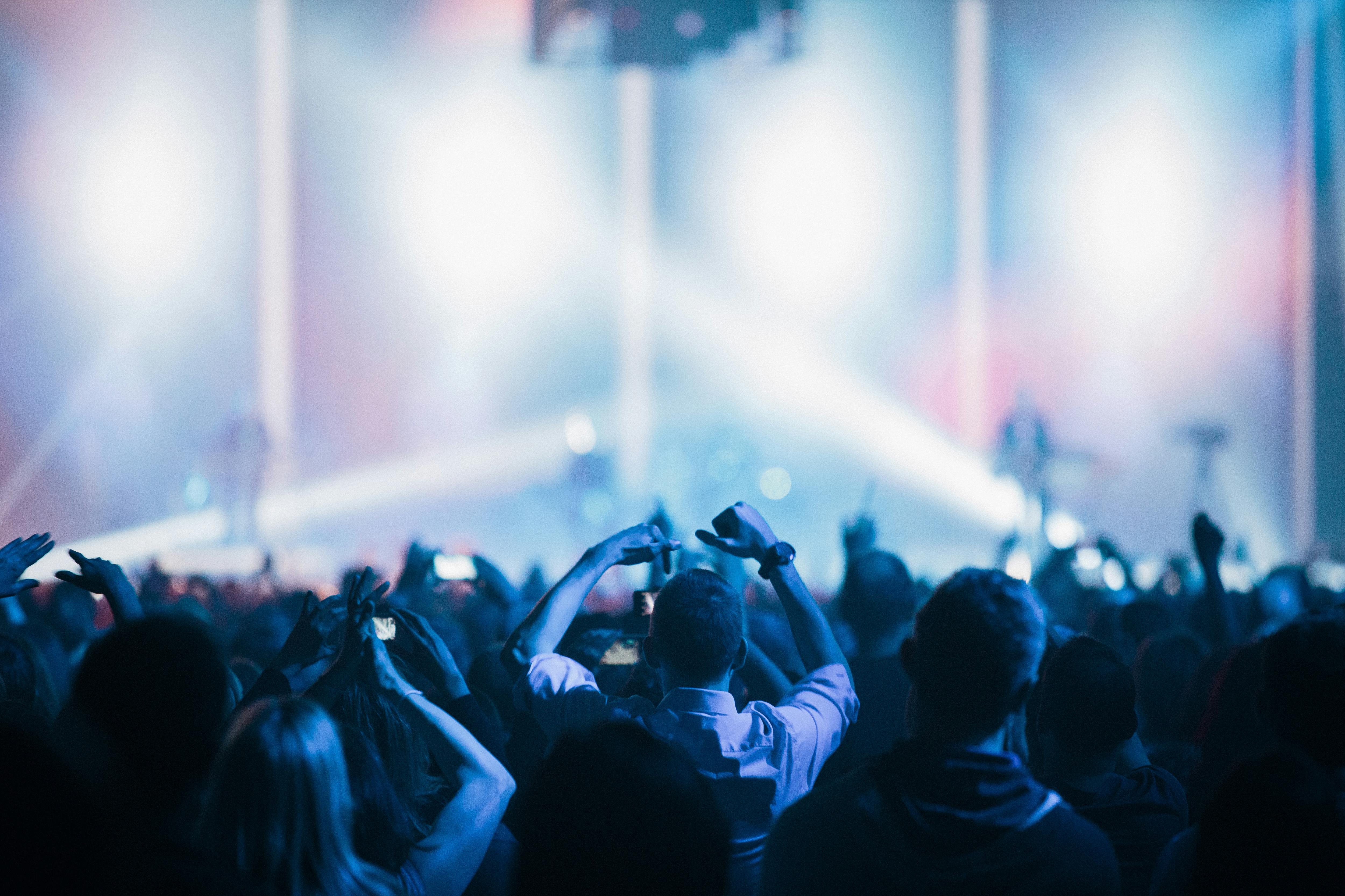 Concert crowd under bright stage lights — the live Ren music experience awaiting on sabbatical