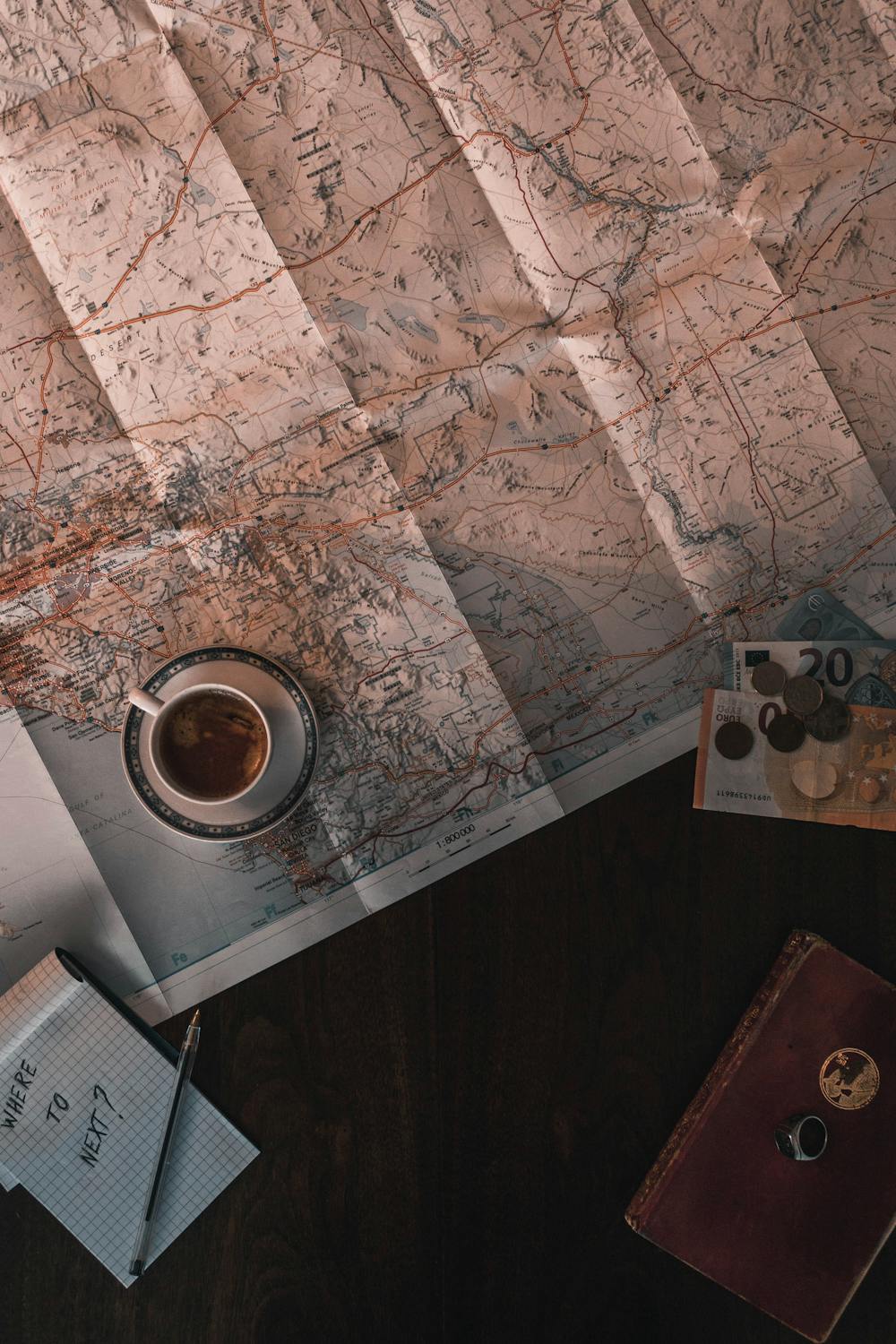 Travel planning flat lay with map, coffee, notebook and passport - sabbatical budget planning