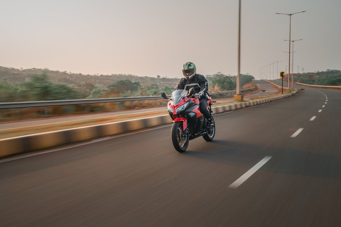 Man riding motorcycle on an open road - the freedom and risk of long-term travel