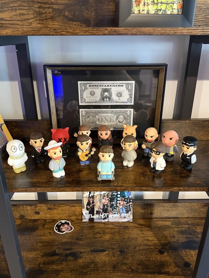 Ren figurine collection and framed Money Game artwork on a shelf